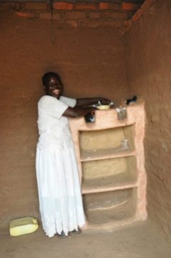 Showing off her cupboard. These are made of mud, with no wood support.
